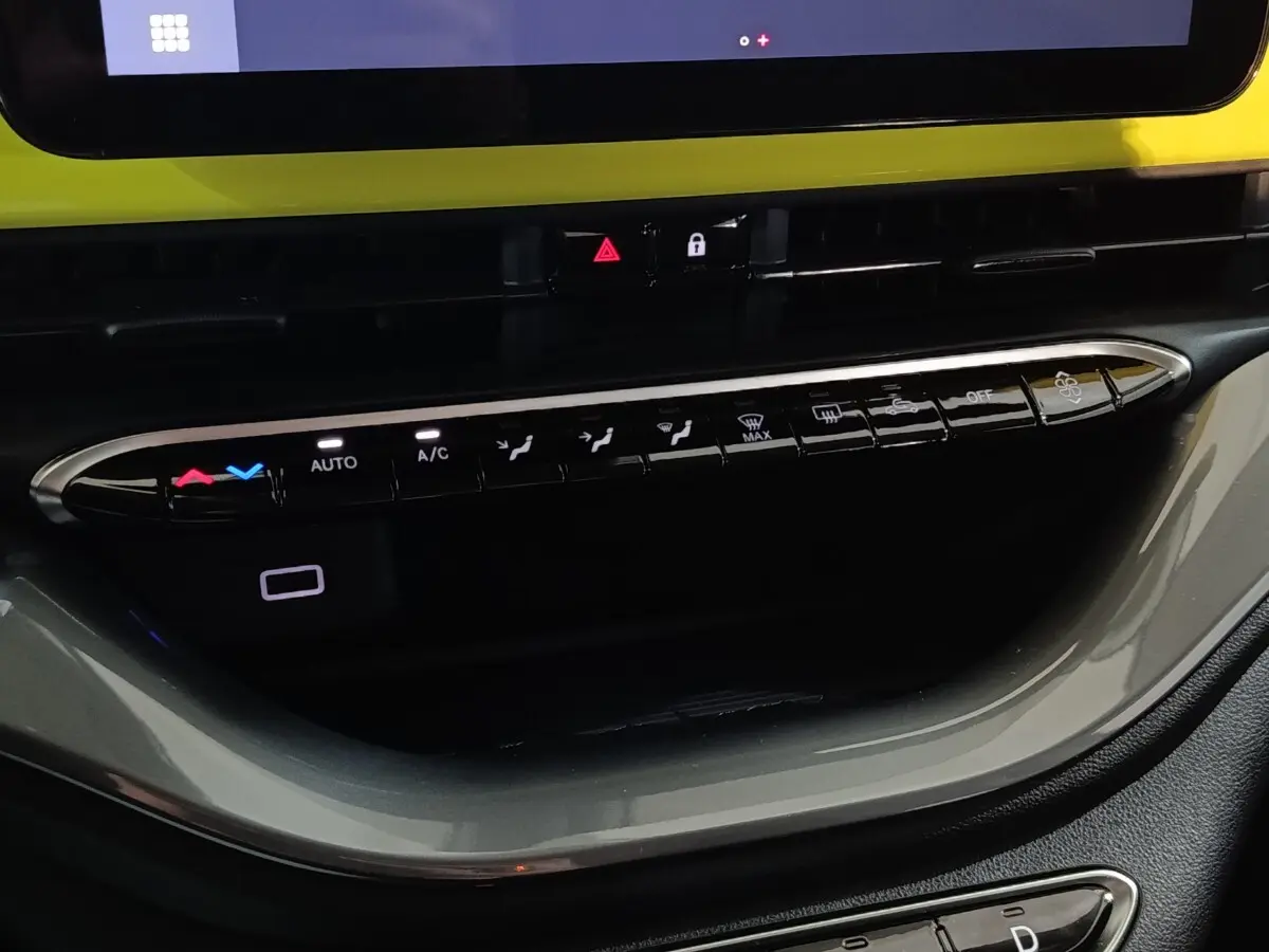 Vue rapprochée de la console centrale du Fiat 500 BEV 24KWH 2024, boutons de climatisation et écran tactile visible.