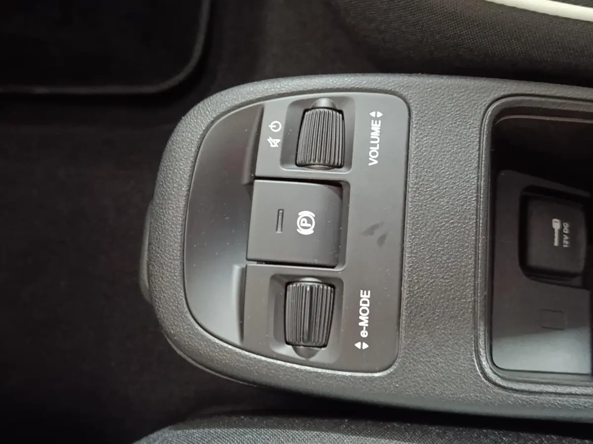 Gros plan sur la console centrale de la FIAT 500 BEV 24KWH 2024, boutons volume et e-mode visibles.