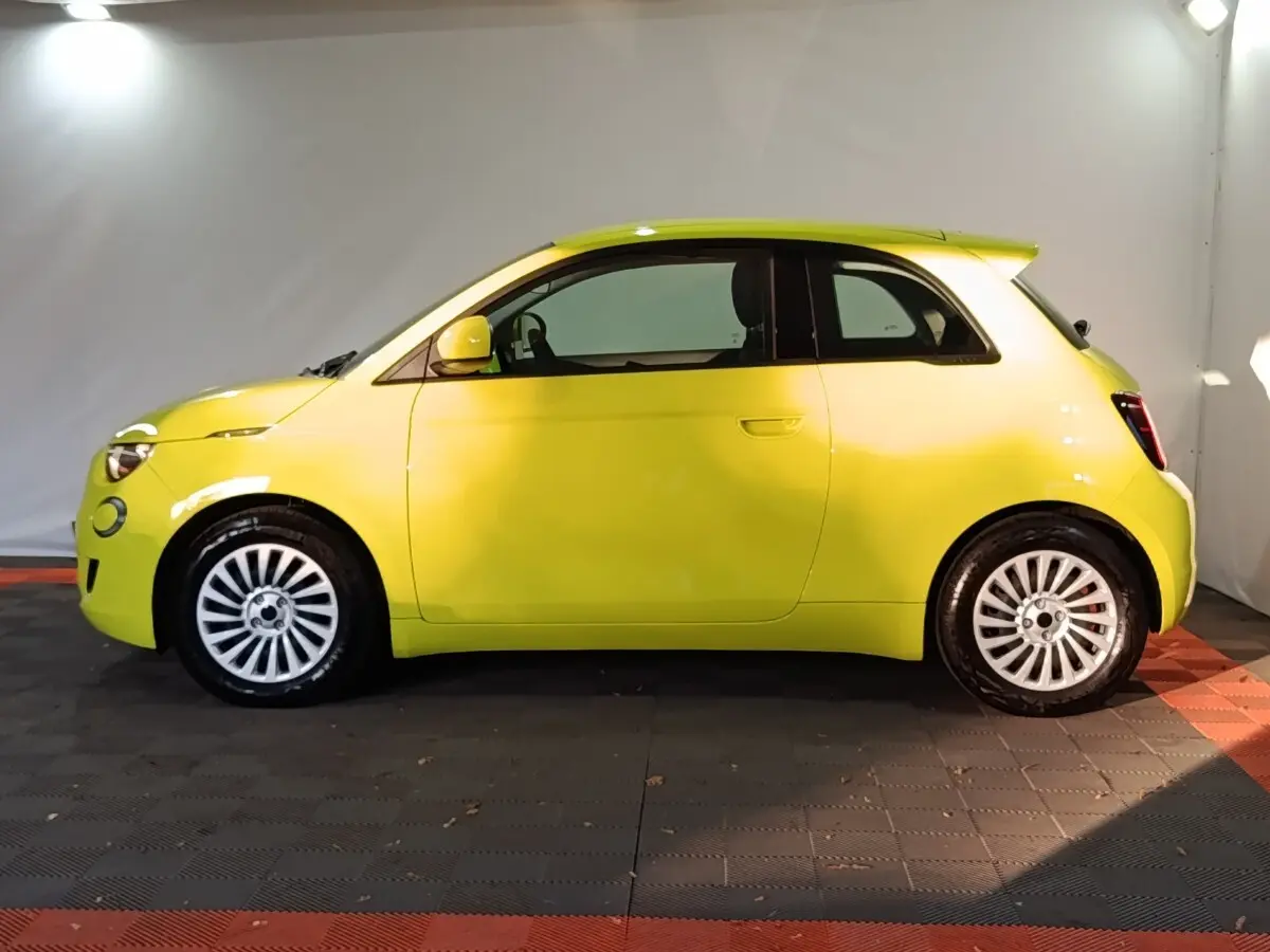 Profil côté gauche d'une FIAT 500 BEV 24KWH jaune 2024, avec jantes blanches et toit arrondi distinctif.
