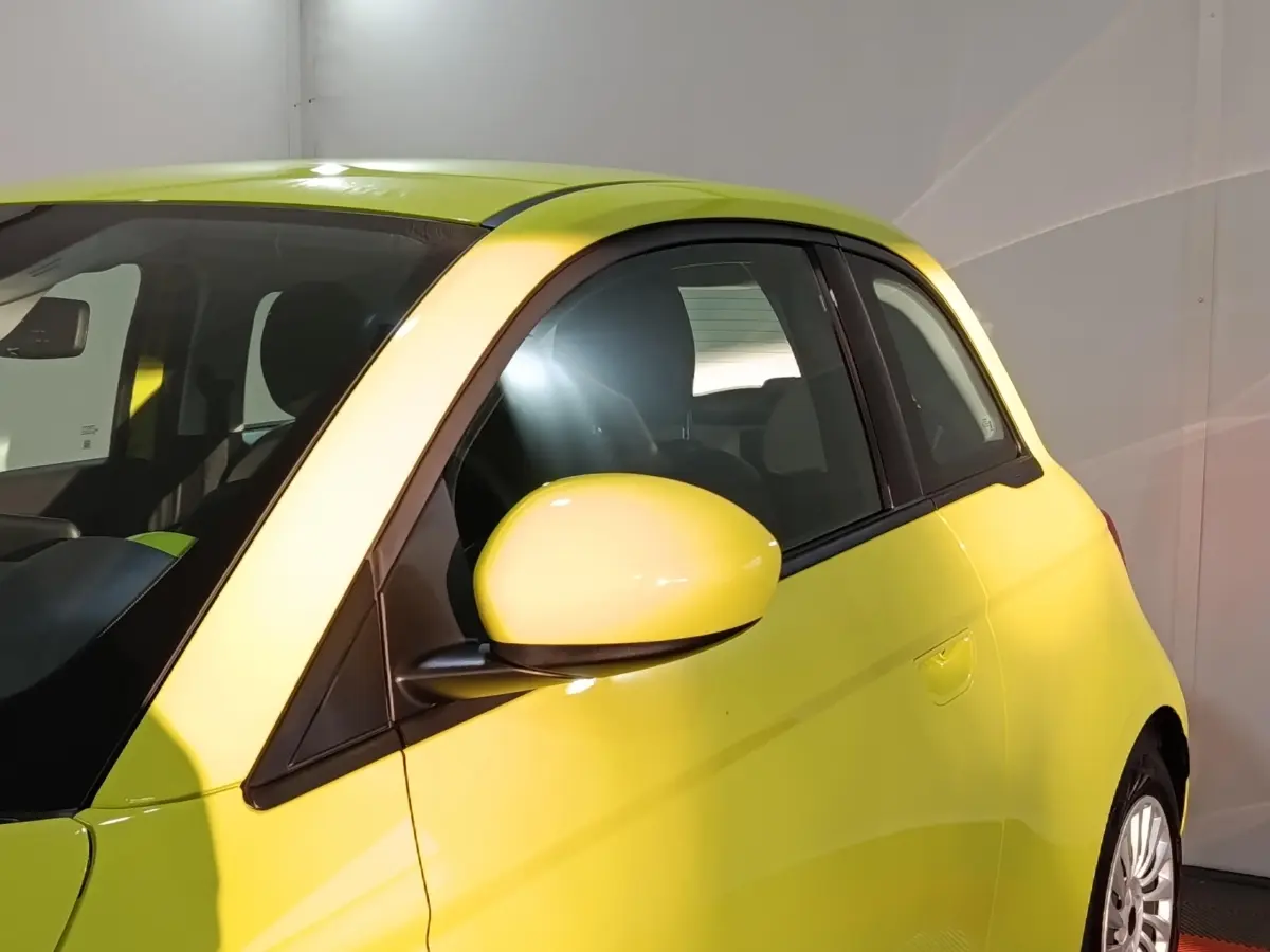 Vue côté gauche rapprochée d'une FIAT 500 BEV 24KWH jaune électrique, mettant en valeur la portière et le rétroviseur.