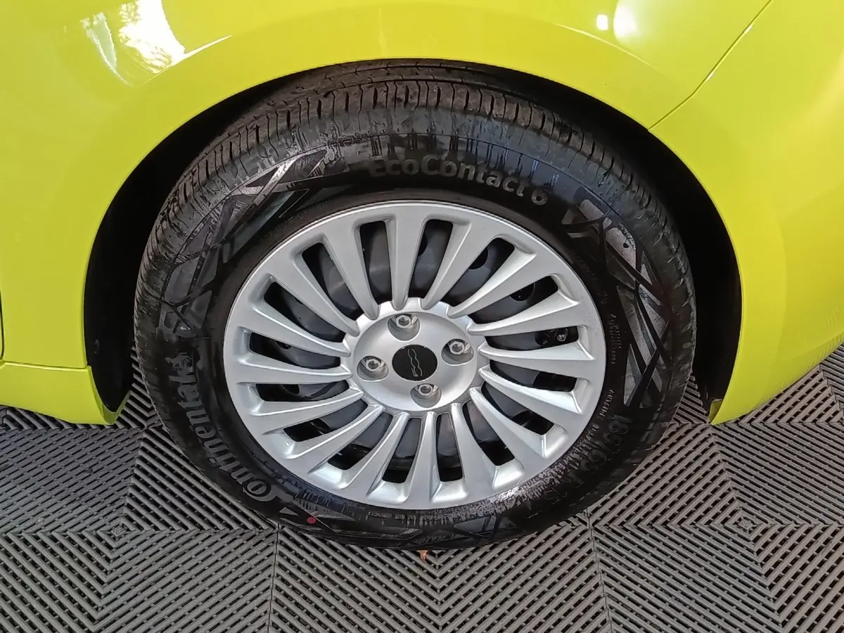 Gros plan sur la roue avant gauche d'une FIAT 500 BEV 24KWH jaune, avec jante argentée multi-branches.