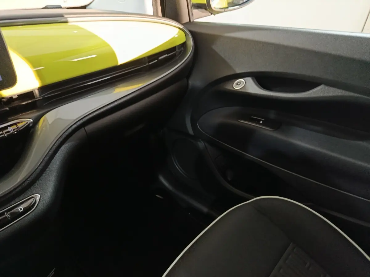 Vue intérieure côté passager du tableau de bord noir et jaune vif du Fiat 500 BEV 24 kWh 2024.