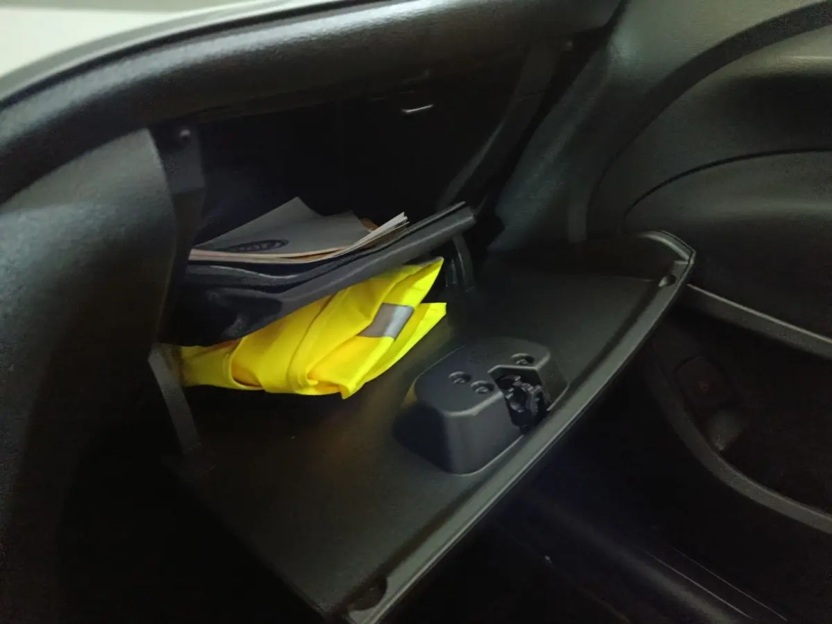 Gant de sécurité jaune visible dans la boîte à gants ouverte côté passager d'une Fiat 500 BEV 24KWH 2024.