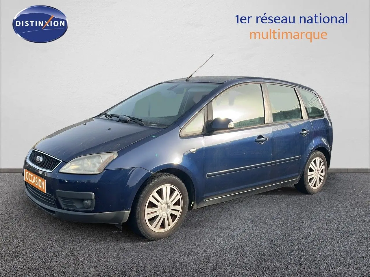 Ford C-MAX bleu foncé métal vu en 3/4 avant droit, montrant ses jantes alliage et ses lignes compactes.