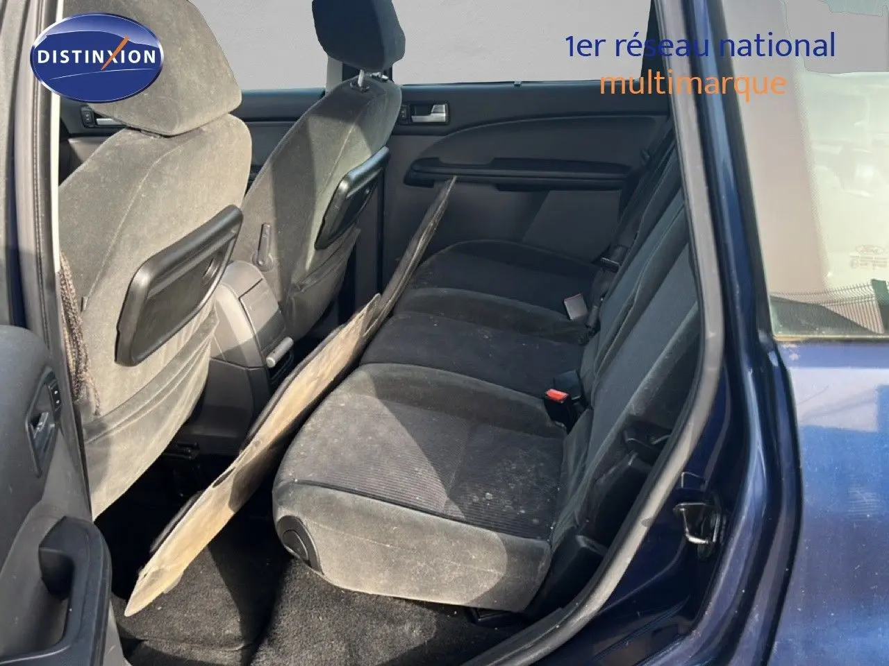 Vue intérieure côté droit montrant la banquette arrière en tissu gris foncé d’un Ford C-MAX bleu foncé 2005.