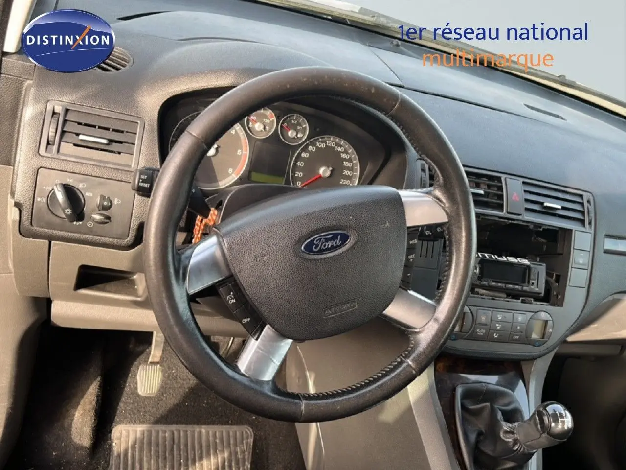 Vue rapprochée de l’intérieur d’une Ford C-MAX 2005, volant cuir et levier de vitesse manuel visibles.