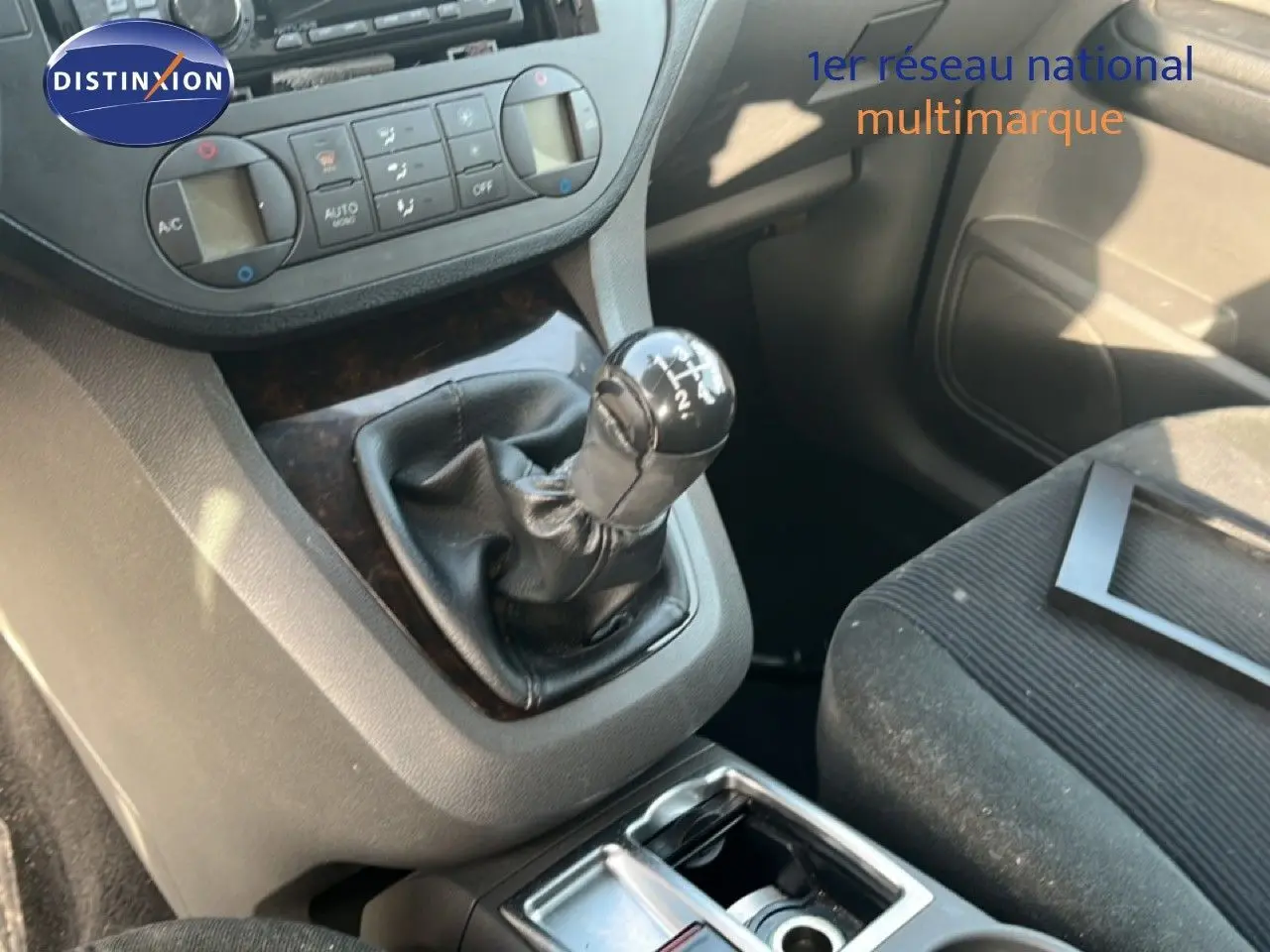 Gros plan sur la boîte manuelle et la console centrale d’un Ford C-MAX 1.6 TDCI bleu foncé, intérieur tissu noir.