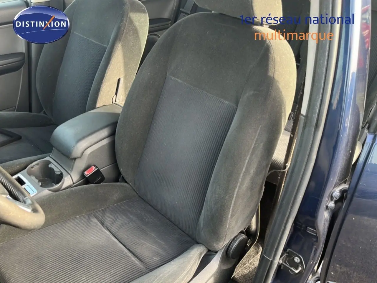 Vue intérieure sur les sièges avant en tissu noir gris d'une Ford C-MAX bleu foncé, porte avant droite ouverte.
