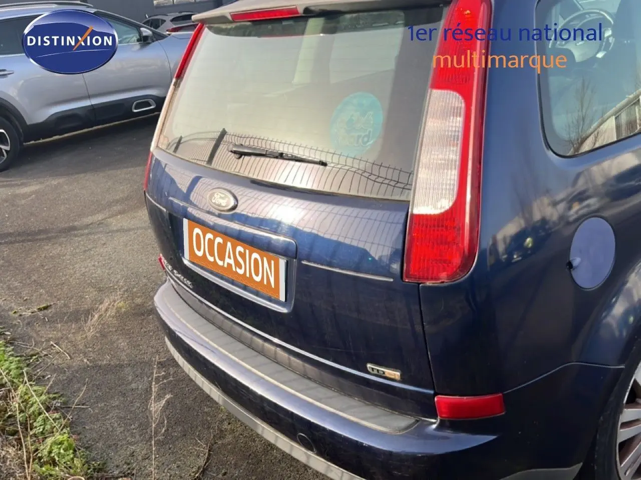 Vue 3/4 arrière droite d'une Ford C-MAX bleu foncé métal de 2005 avec feux arrière verticaux et hayon fermé.