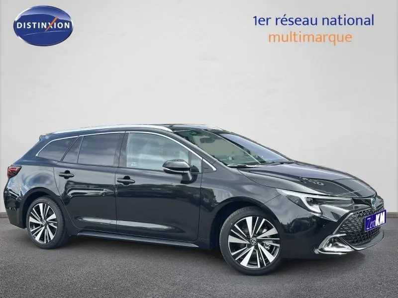 Toyota Corolla 1.8 Hybrid noire vue de profil côté gauche, avec jantes alliage et calandre sportive.