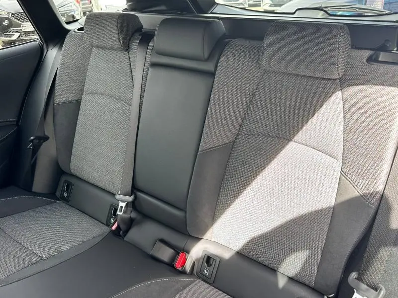 Vue rapprochée de la banquette arrière en tissu noir et gris de la Toyota Corolla 2025 hybride, avec ceinture et fixation Isofix visibles