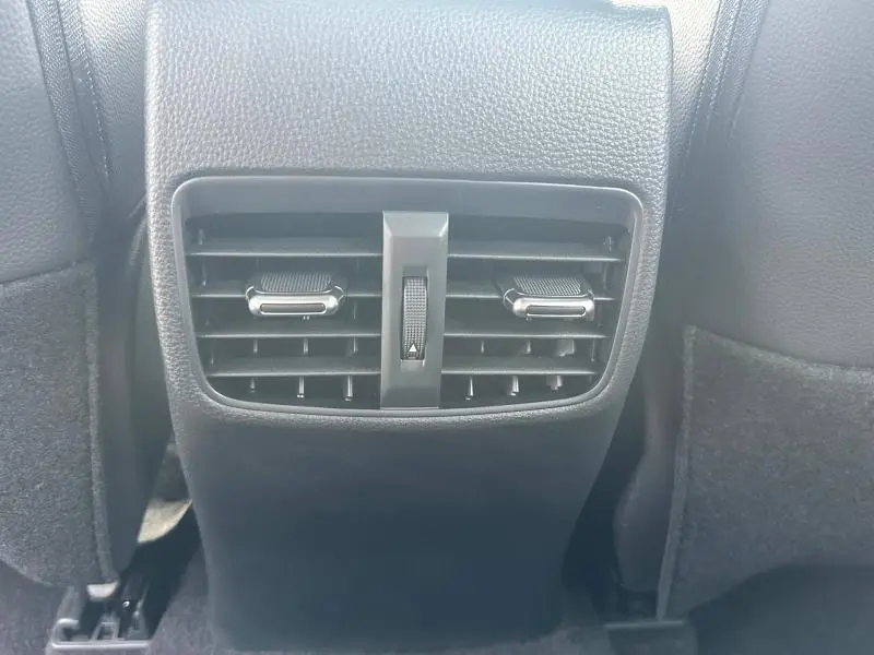 Grille d'aération arrière noire de la Toyota Corolla 1.8 Hybrid 2025, vue rapprochée entre les sièges avant.