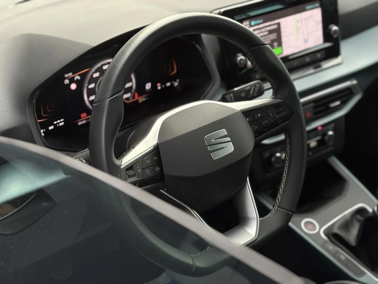 Volant cuir multifonction SEAT Arona TSI 115 Xpérience en gros plan avec tableau de bord numérique et console centrale.