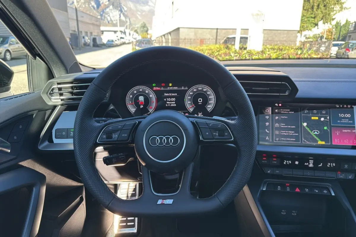 Vue intérieure centrée sur le volant cuir méplat S-Line et le tableau de bord numérique de l'Audi A3 2025.