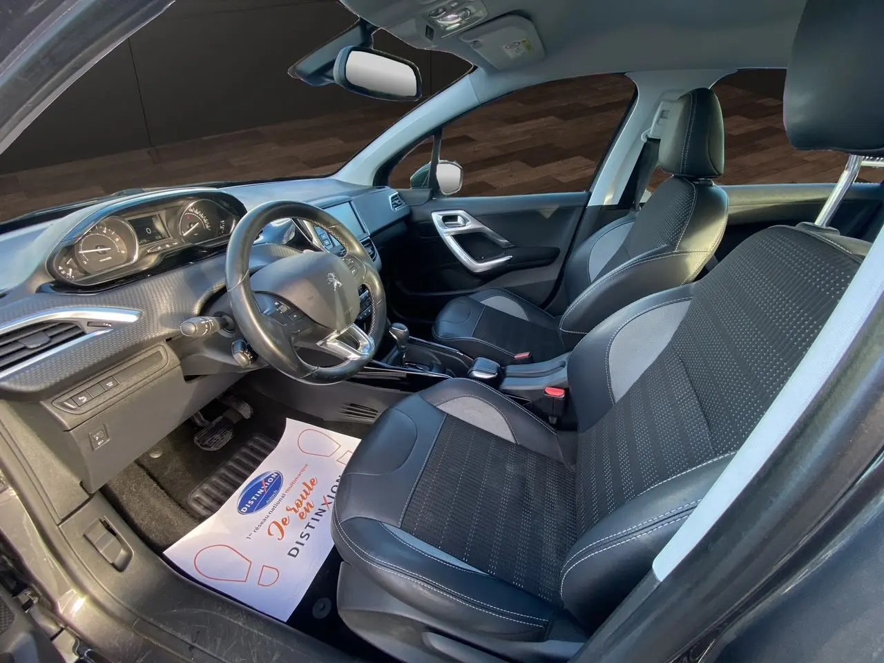 Intérieur de la Peugeot 2008 2019 vu côté conducteur, sièges tissu noir et gris avec volant multifonction.