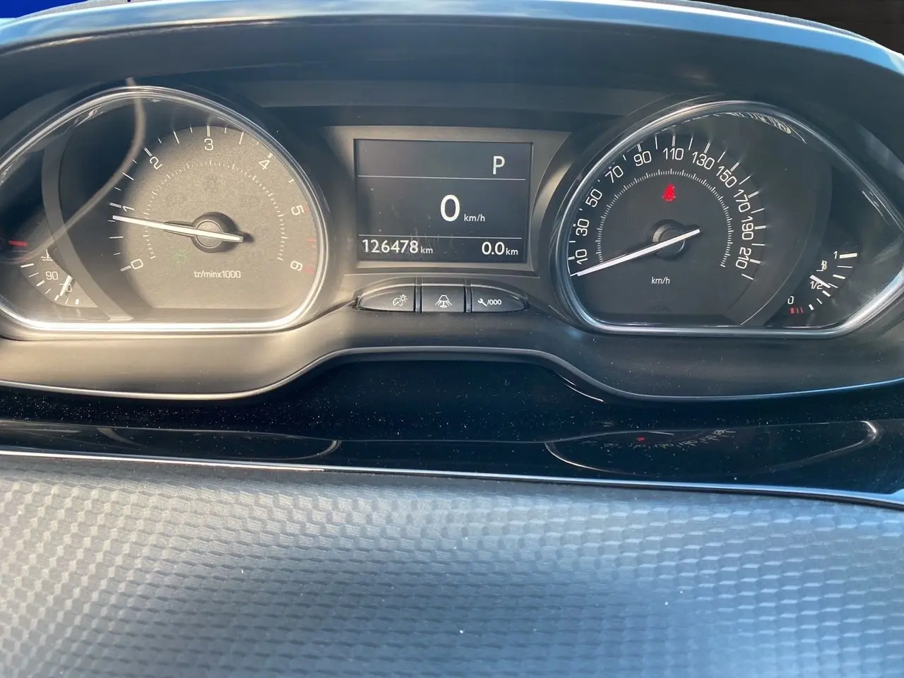 Vue rapprochée du tableau de bord du Peugeot 2008 gris platinium, affichant le compteur et l’odomètre à 126478 km.