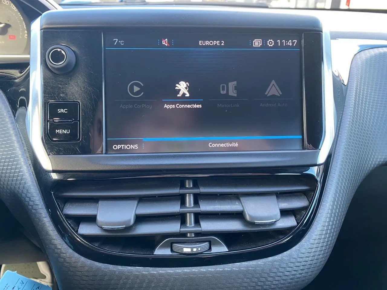 Vue rapprochée de l’écran tactile central et des aérateurs du tableau de bord du Peugeot 2008 gris platinium de 2019.