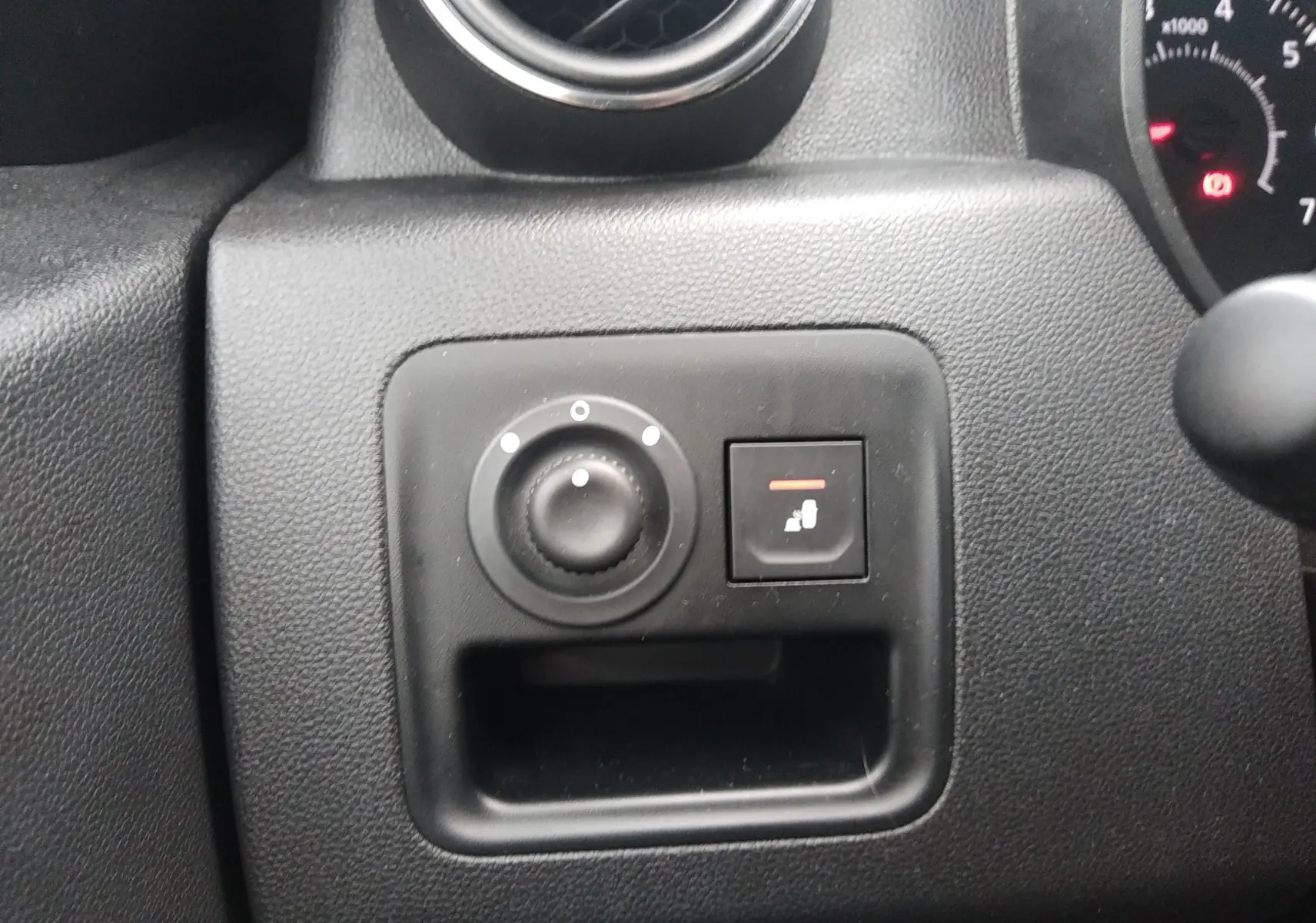 Gros plan sur les commandes de réglage des rétroviseurs et siège chauffant du tableau de bord d'un Dacia Duster 2021.