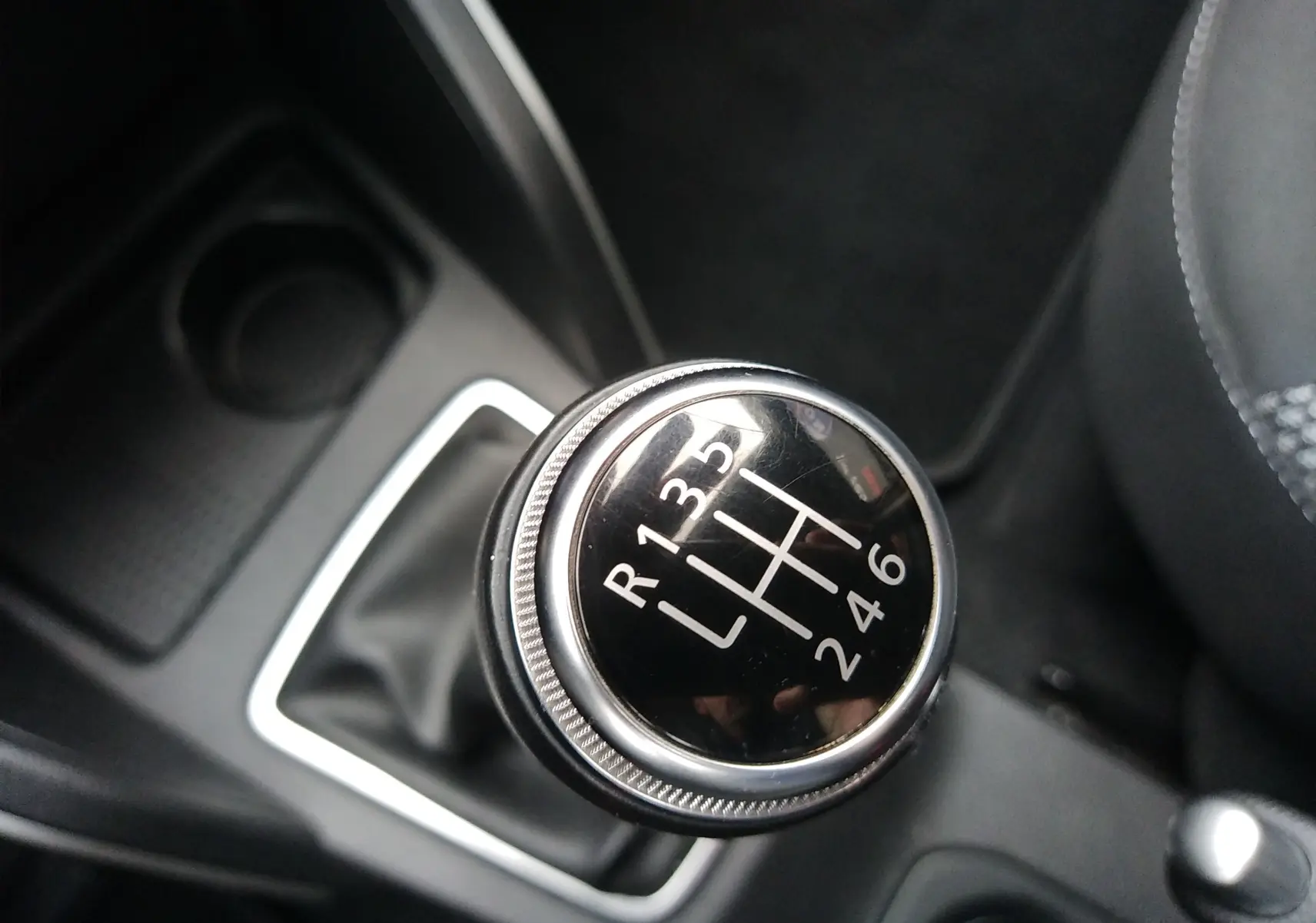 Gros plan sur le levier de vitesses manuel du Dacia Duster 2021, intérieur noir avec coutures grises visibles.