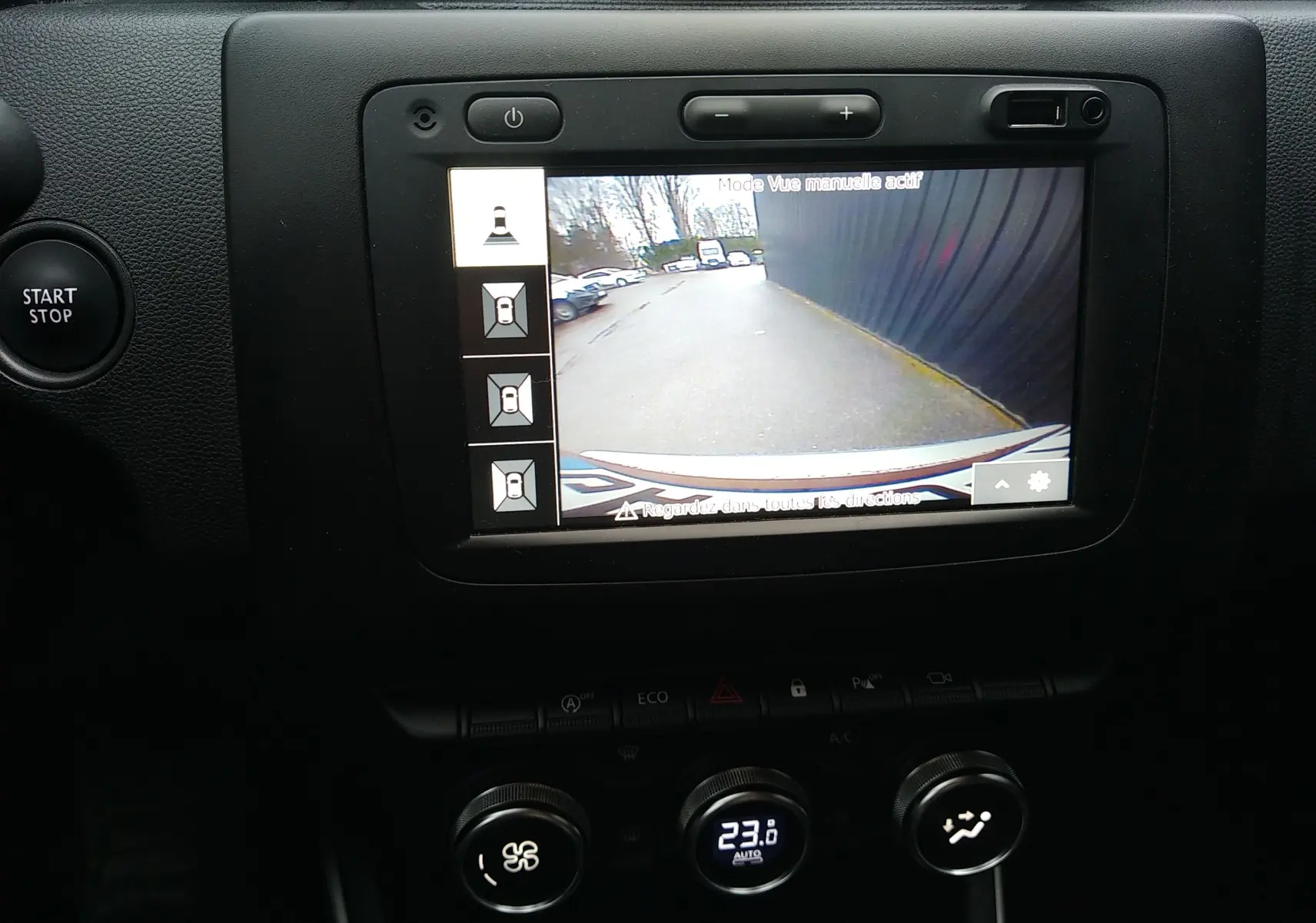 Vue intérieure du tableau de bord du Dacia Duster 2021, écran de caméra de recul avec affichage clair et commandes climatisation visibles.