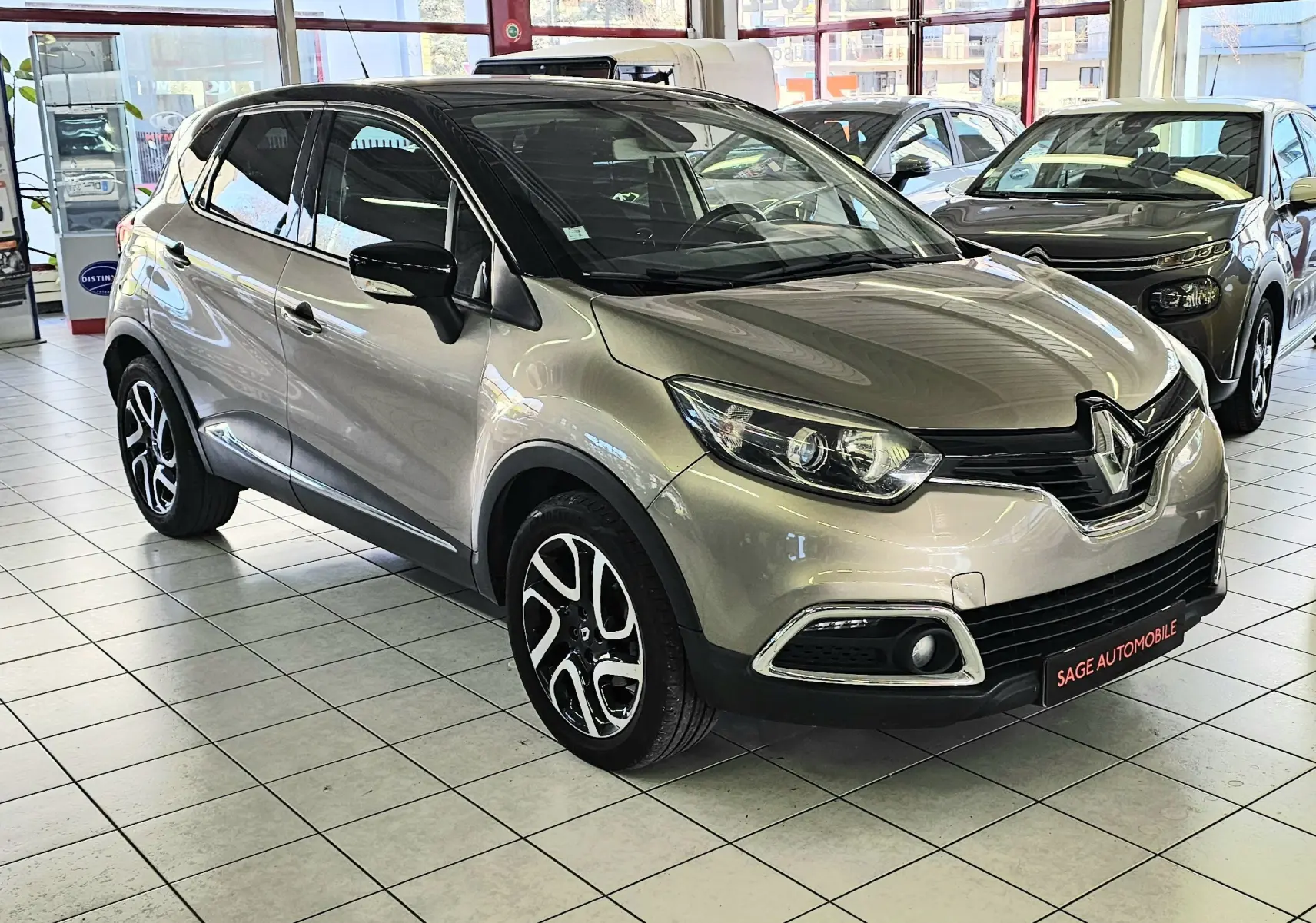 Renault Captur gris vue 3/4 avant droit en intérieur, avec jantes alliage et toit noir contrasté.