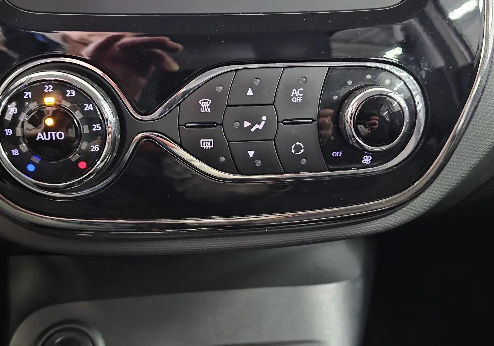 Gros plan sur la commande de climatisation automatique du tableau de bord du Renault Captur gris de 2014.