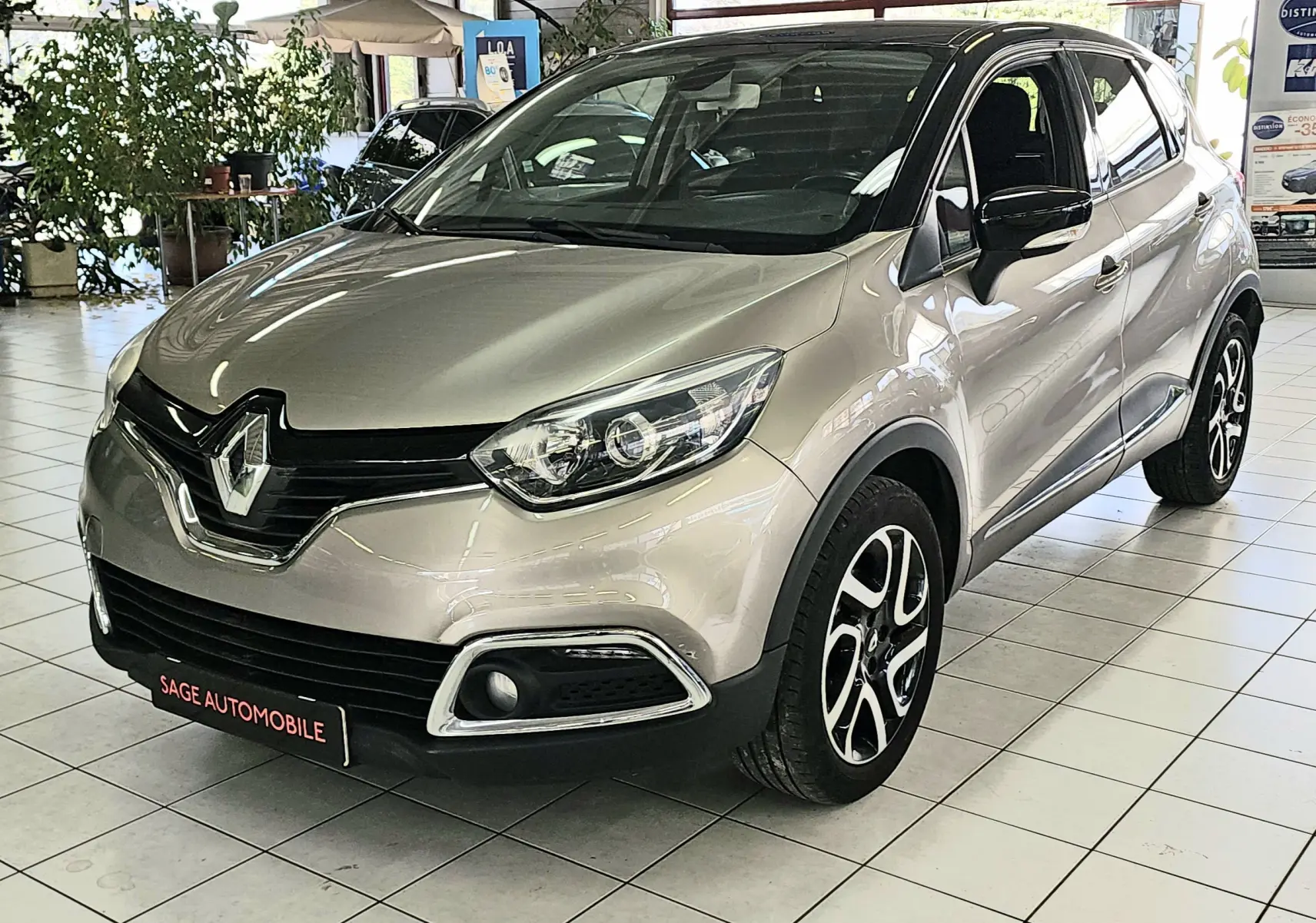 Vue 3/4 avant d’un Renault Captur gris métallisé de 2014 avec jantes alliage et calandre noire brillante.