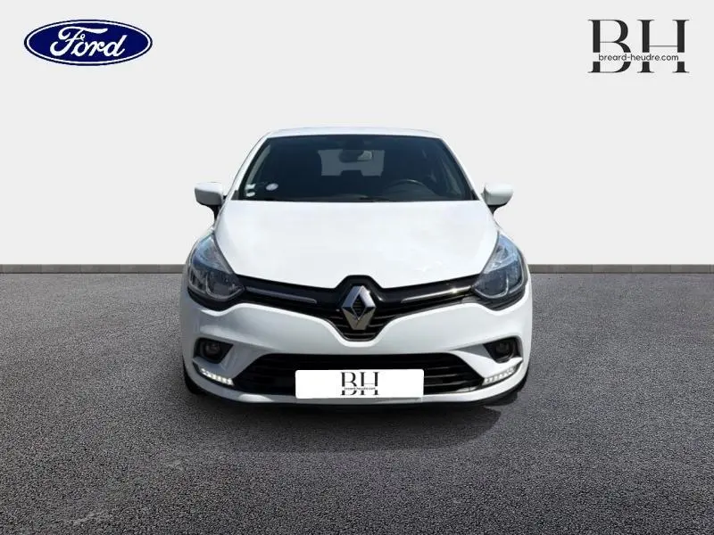 Vue avant d'une Renault Clio blanche 2018 avec calandre noire et feux diurnes LED visibles.