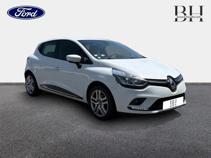 Renault Clio blanc glacier vue 3/4 avant droit, avec phares LED et jantes alliage visibles.