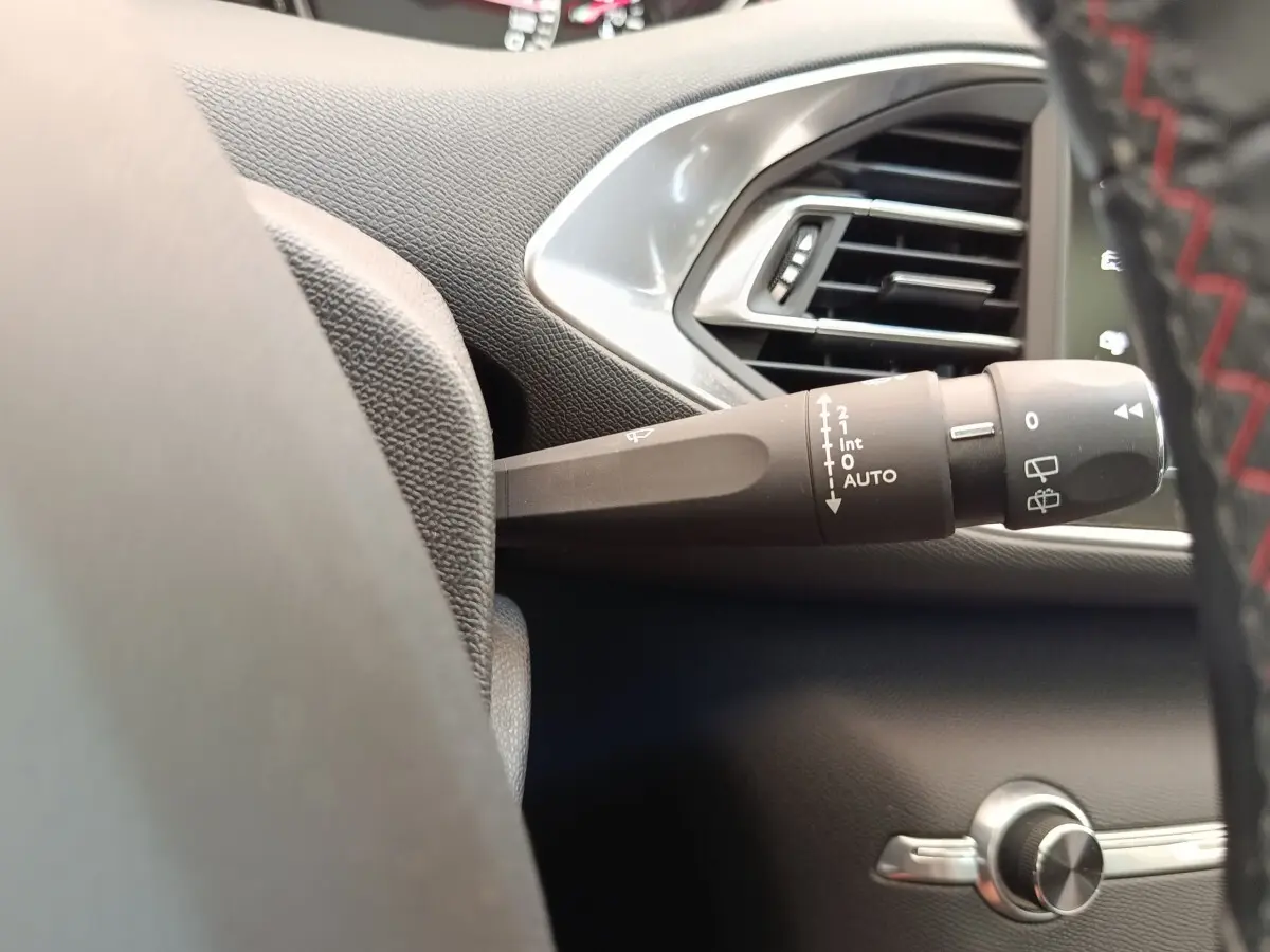 Gros plan sur la commande d’essuie-glace côté gauche du tableau de bord noir de la Peugeot 308 GT Line.