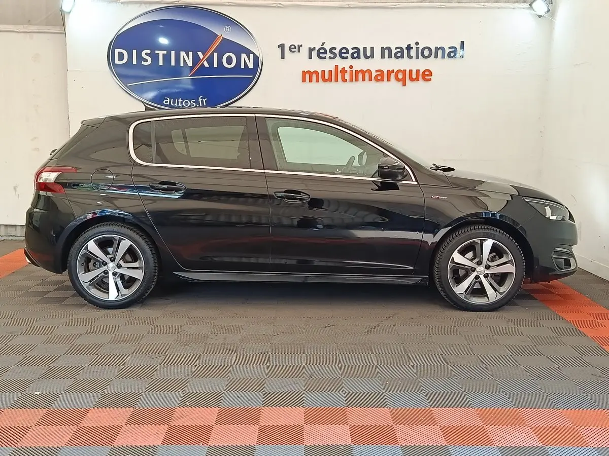 Profil côté gauche d'une Peugeot 308 noire GT Line 2016, avec jantes alliage et logo GT Line visible sur l'aile avant.