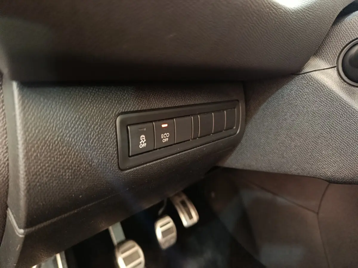 Gros plan sur les commandes de désactivation ESP et mode ECO, tableau de bord noir de la Peugeot 308 GT Line 2016.