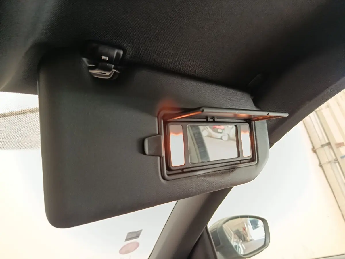 Détail du pare-soleil intérieur avec miroir éclairé, côté conducteur, dans une Peugeot 308 noire de 2016.