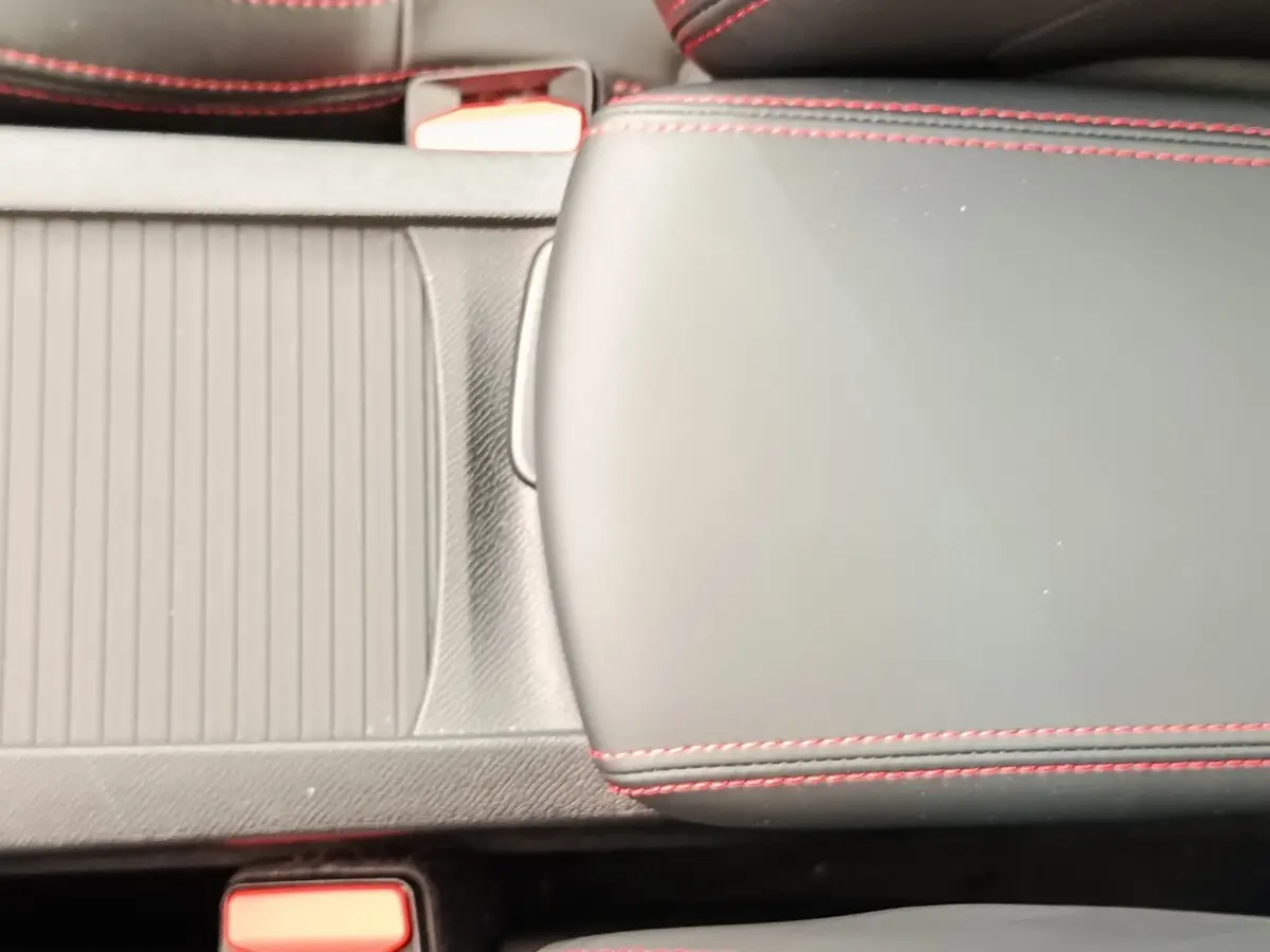Gros plan sur l'accoudoir central noir avec surpiqûres rouges dans l'habitacle d'une Peugeot 308 GT Line 2016.