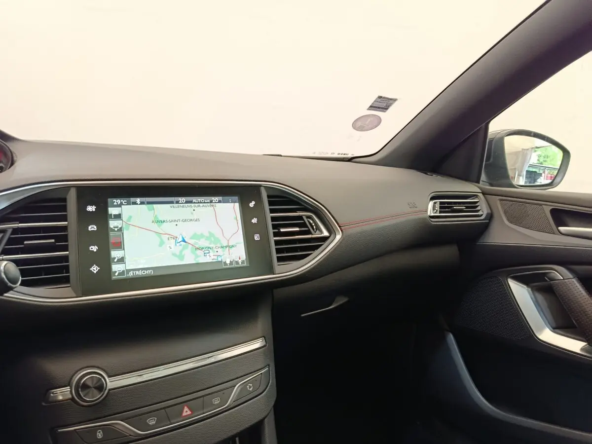 Vue intérieure côté passager du tableau de bord noir de la Peugeot 308 GT Line avec écran tactile de navigation 9,7 pouces.