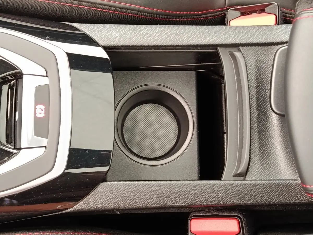 Vue plongeante sur la console centrale noire de la Peugeot 308 GT Line 2016 avec porte-gobelet et surpiqûres rouges.