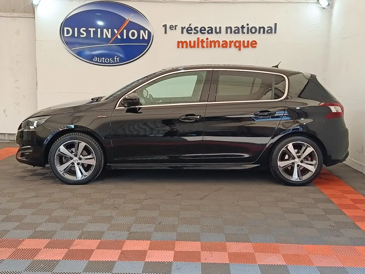 Vue latérale droite d'une Peugeot 308 noire GT Line de 2016, avec jantes alliage et logo GT sur l'aile avant.