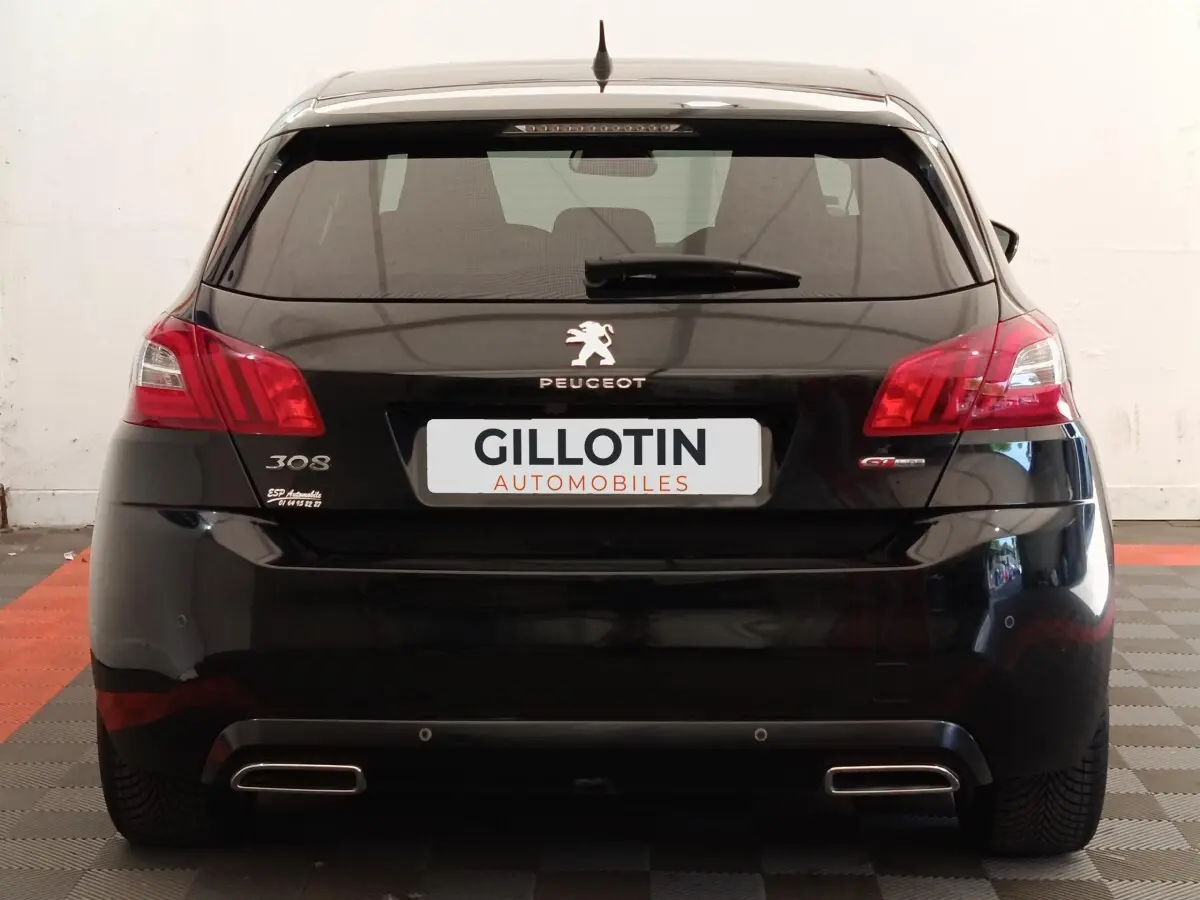 Vue arrière d'une Peugeot 308 noire GT Line de 2016 avec feux rouges et double sortie d'échappement chromée.