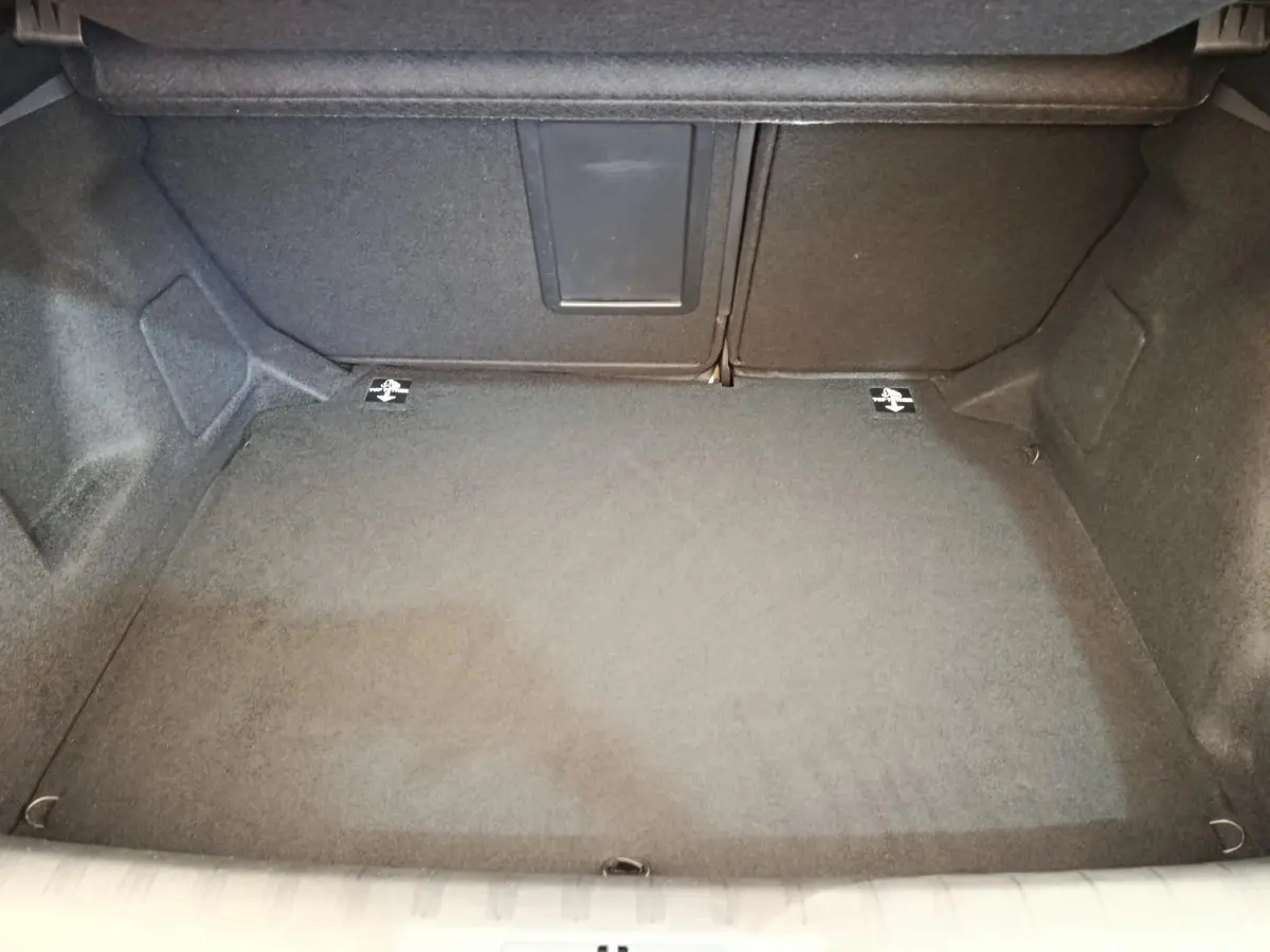 Coffre ouvert de la Peugeot 308 noir, vue intérieure montrant la banquette rabattable avec trappe à ski.