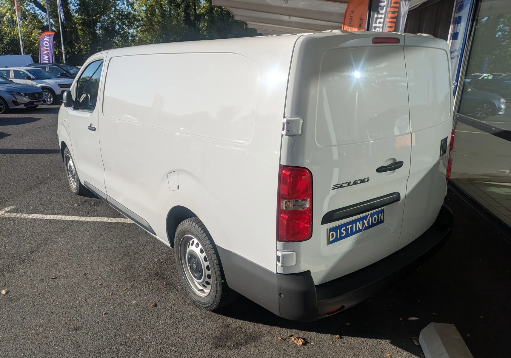 Fiat Scudo Fourgon blanc vu en 3/4 arrière droit, avec jantes tôles grises et portes arrière fermées.