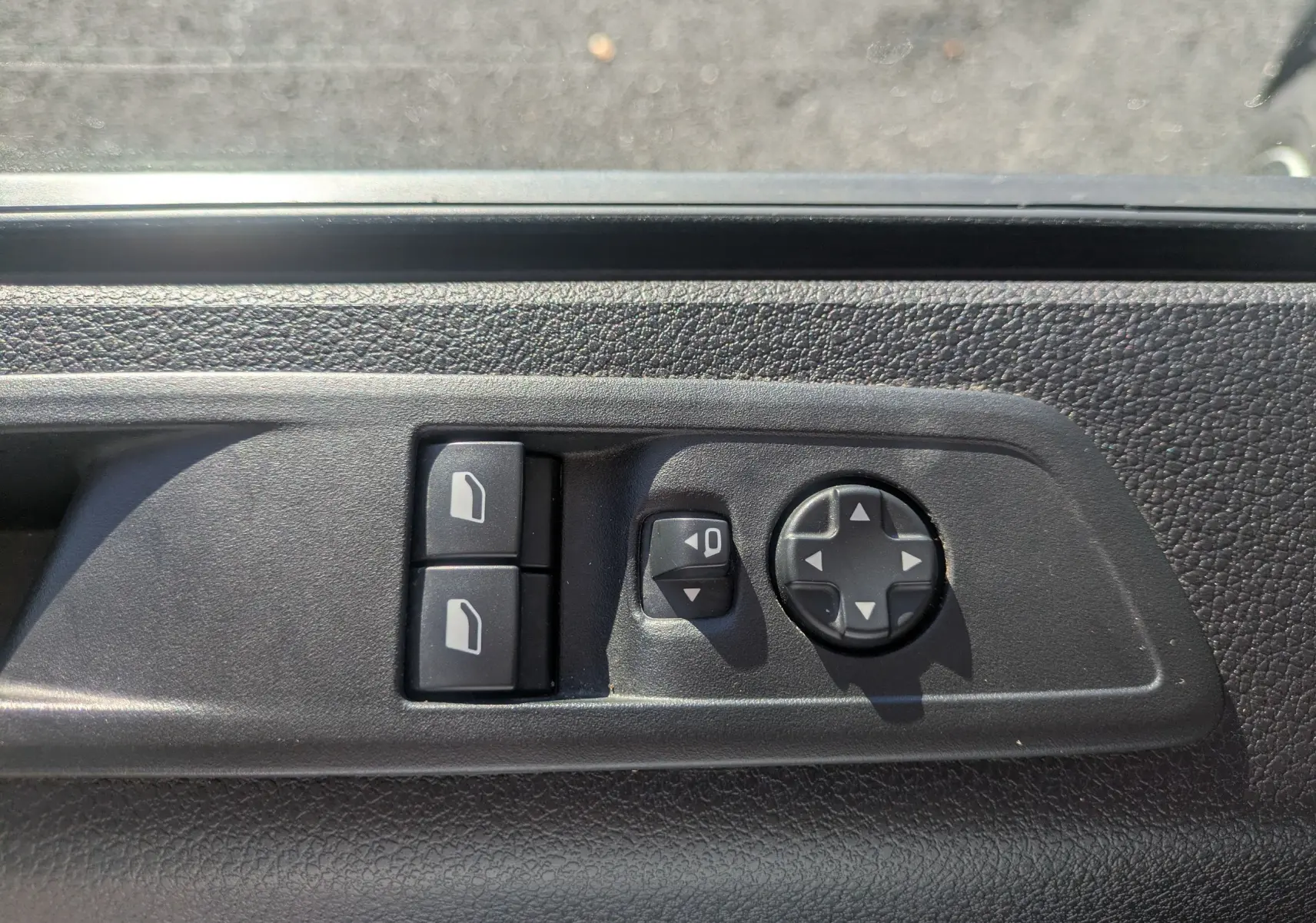 Gros plan sur les commandes de réglage des vitres et des rétroviseurs côté conducteur du FIAT Scudo Fourgon blanc 2025.