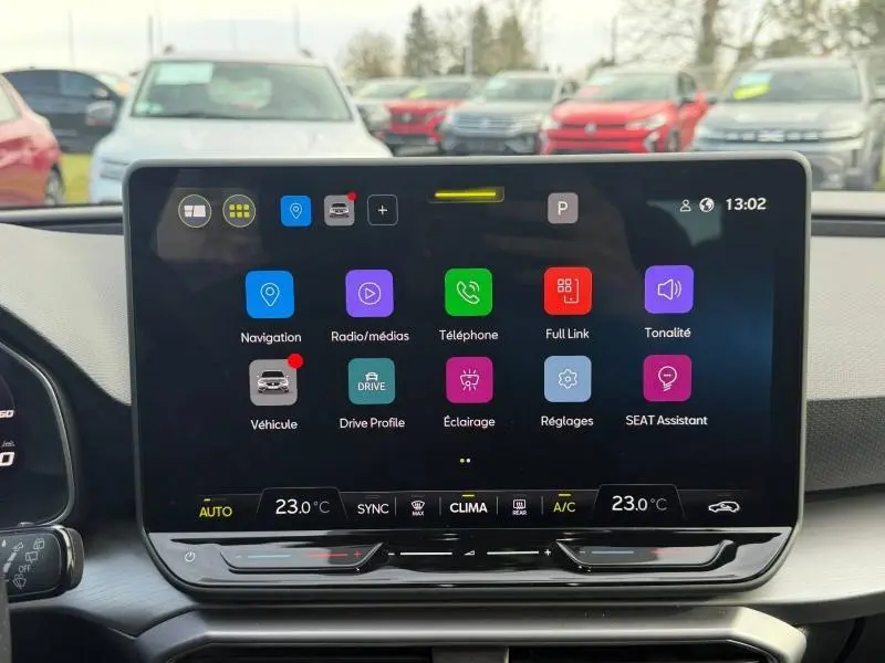 Écran tactile central du tableau de bord du SEAT LEON ST 2025, affichant les options multimédia et climatisation.