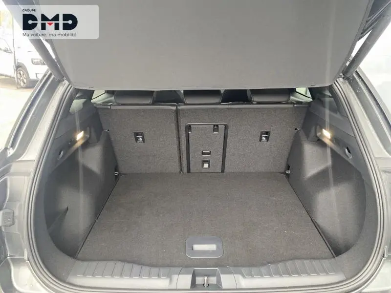 Coffre ouvert vu de l'arrière d'un Ford Explorer gris Magnetic, montrant l'espace de chargement et banquette arrière rabattable.