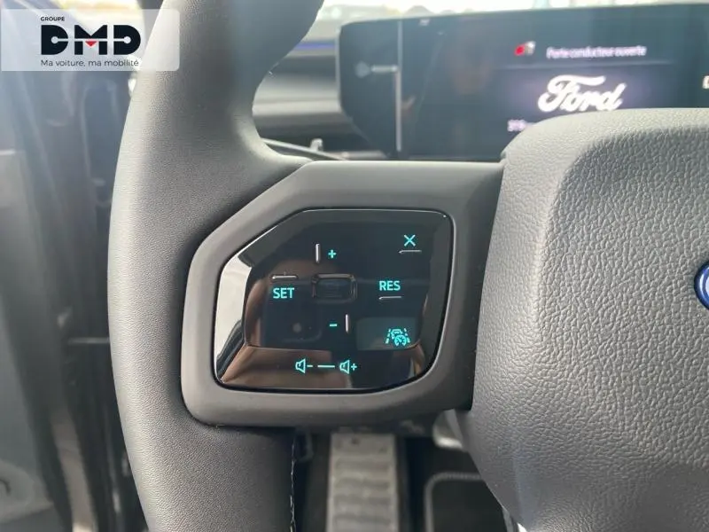 Gros plan sur les commandes au volant à gauche du Ford Explorer gris Magnetic, avec écran digital en arrière-plan.