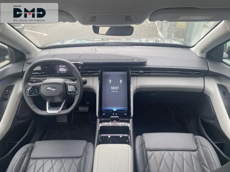 Vue intérieure avant du Ford Explorer 2025 gris Magnetic, avec tableau de bord moderne et écran tactile vertical central.