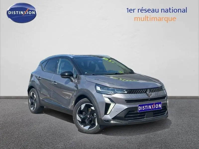 Renault Captur 1.6 E-Tech hybride 2025 en 3/4 avant, gris Cassiopée métallisé avec toit noir et jantes alu noires.
