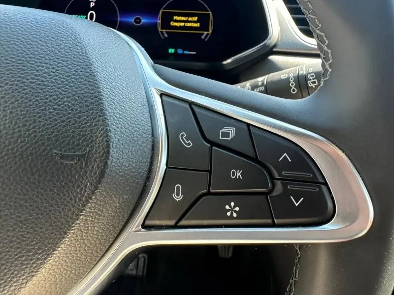 Gros plan sur les commandes multifonctions à droite du volant noir du Renault Captur 1.6 E-Tech 2025.