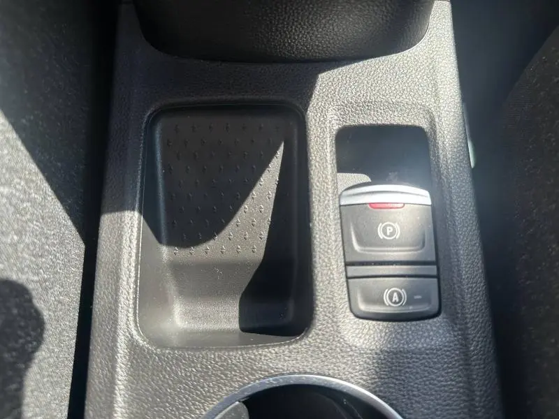 Gros plan sur la console centrale noire du Renault Captur 1.6 E-Tech avec commande de frein à main électronique et rangement adjacent.