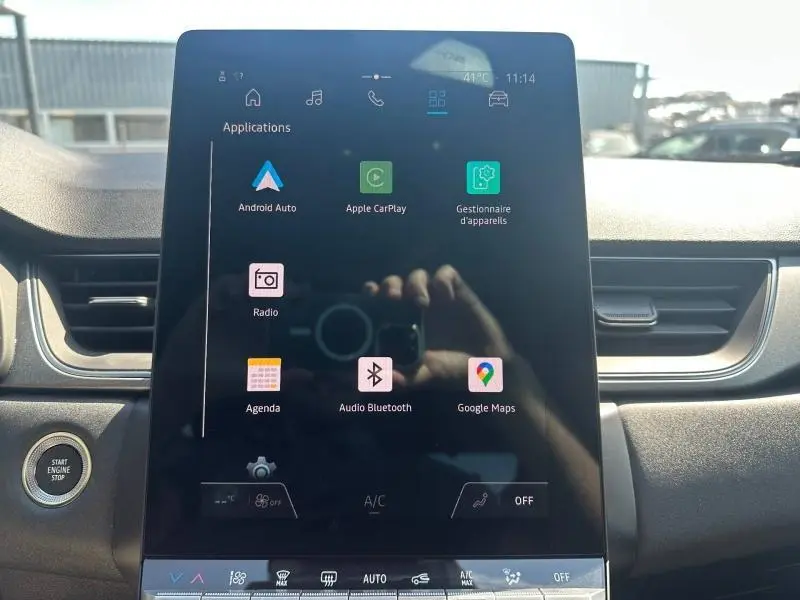 Écran tactile central allumé dans l’habitacle du Renault Captur 2025, avec commandes multimédia visibles.