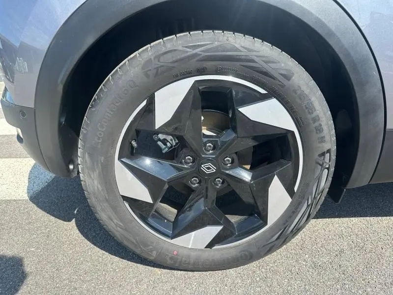 Gros plan sur la roue avant gauche du Renault Captur 2025 gris Cassiopée métallisé avec jante alu noire et argentée.